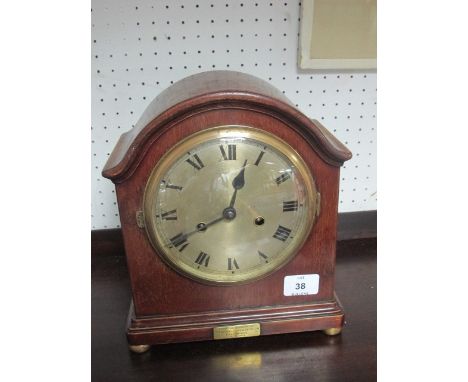 A MAHOGANY CASED MANTLE CLOCK the rectangular arched case with silvered dial and Roman numerals raised on brass bun feet 28cm