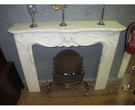 AN ART DECO STYLE WHITE MARBLE CHIMNEY PIECE the serpentine moulded shelf above a figural carved frieze raised on carved flow