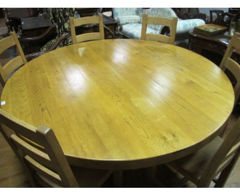 A SEVEN PIECE BREAKFAST SUITE comprising an oak table of circular outline raised on moulded base together with six beechwood 