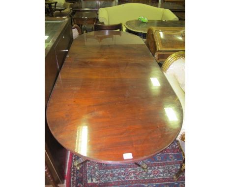 A REGENCY STYLE MAHOGANY D-END DINING TABLE of rectangular form with rounded ends and one loose leaf raised on twin tripod su