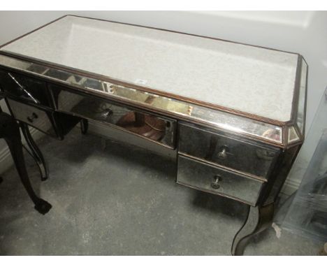 A MIRRORED SIDE TABLE the rectangular top above three frieze drawers on sabre legs 83cm (h) x 123cm (w) x 56cm (d)