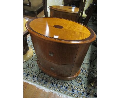 AN OAK FILING CABINET of oval outline the shaped moulded top with inlaid panel and two frieze drawers on platform support 77c