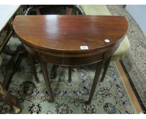 AN EDWARDIAN MAHOGANY FOLD OVER CARD TABLE of demi-lune outline the hinged top with a baize lined interior above a plain frie