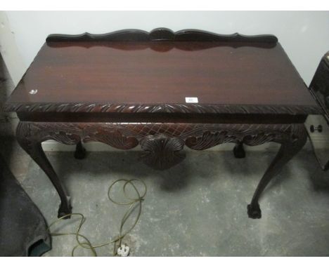 A CHIPPENDALE STYLE MAHOGANY SIDE TABLE the rectangular top with gadrooned rim above a carved frieze on cabriole legs with cl