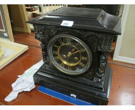 A BLACK SLATE MANTLE CLOCK the rectangular case with circular dial and Roman numerals between cylindrical ring turned columns