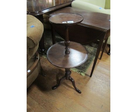 A MAHOGANY TWO TIER DUMB WAITER of circular outline each dish joined by a baluster and ring turned support and tripod base 86