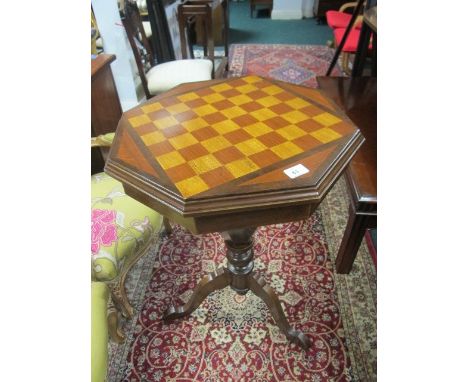 A BEECHWOOD GAMES TABLE of octagonal form with hinged lid raised on a baluster support and tripod base 77cm (h) x 53cm x 53cm