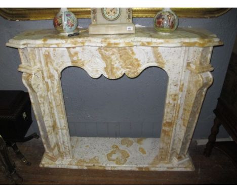 A WHITE AND SIENNA MARBLE CHIMNEY PIECE the serpentine stepped moulded shelf raised on panelled jabs with scroll capitals and