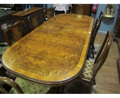 A FINE TEN PIECE WALNUT DINING SUITE comprising eight chairs each with a solid vase shaped splat and upholstered drop in seat