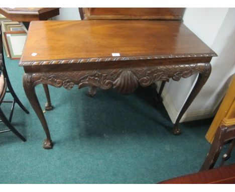 A CHIPPENDALE STYLE MAHOGANY SIDE TABLE the rectangular top with gadrooned rim above a carved frieze on cabriole legs with cl