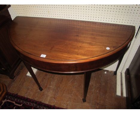 A GEORGIAN MAHOGANY SIDE TABLE of demi-lune outline the shaped moulded top above a plain frieze on square tapering legs with 