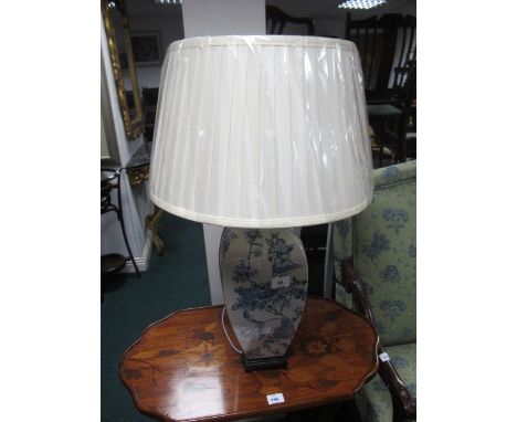 A PORCELAIN TABLE LAMP the white and blue ground decorated with flowerheads and foliage raised on a hardwood base with pleate