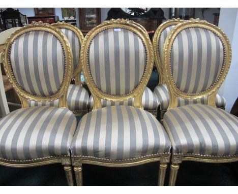 A SET OF SIX CONTINENTAL GILTWOOD AND UPHOLSTERED CHAIRS each with flowerhead cresting above an oval upholstered panel and se