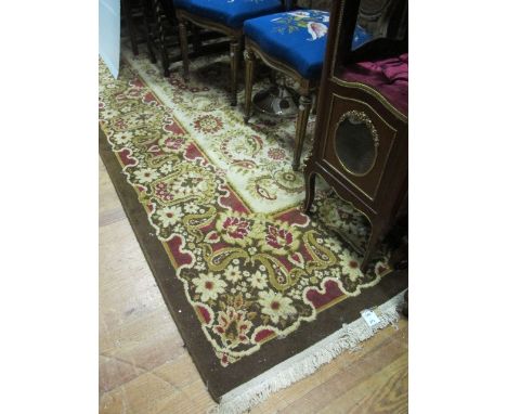 A WOOL RUG the light brown and beige ground with central floral panel within a conforming border 350cm x 250cm