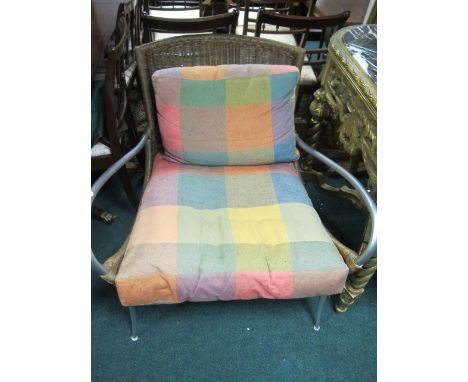 A TUBULAR AND WICKER ARMCHAIR with loose cushions