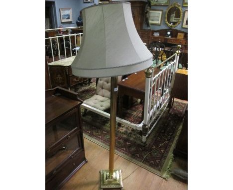 A BRASS FLOOR STANDARD LAMP with Corinthian column above a square stepped base with claw feet 171cm high