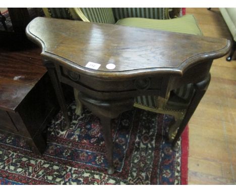 AN OAK SIDE TABLE of serpentine outline the shaped moulded top with frieze drawer on slender cabriole legs with pad feet 70cm