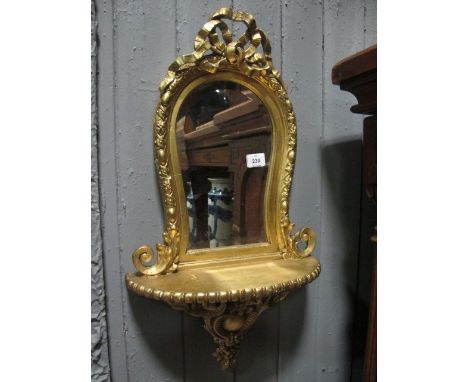 A CONTINENTAL GILT FRAME MIRROR the shaped bevelled glass plate within an egg and dart moulded frame with ribbon tied crestin