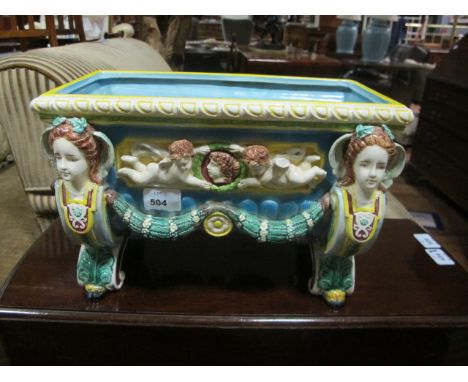A MAJOLICA PLANTER of rectangular form the light blue, green and yellow ground with figural masks moulded in relief with wing