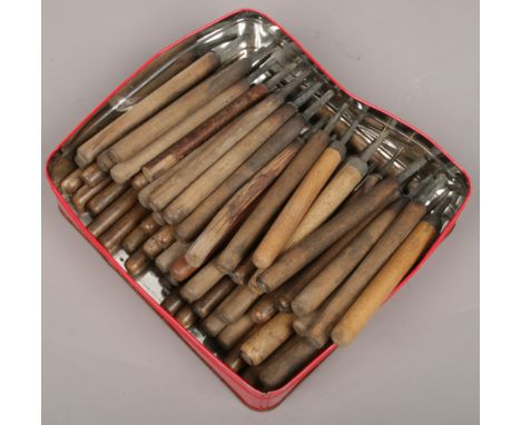 A tin of vintage book binding tools. 