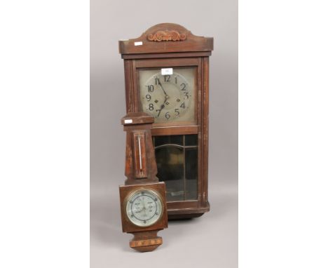 An Edwardian oak wall clock, along with a small oak barometer. 