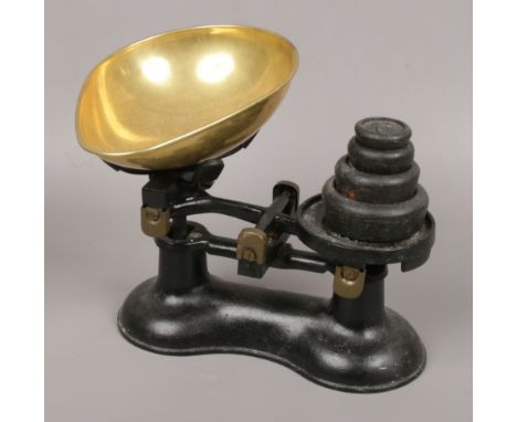 A pair of painted cast iron and brass weighing scales and imperial weights. 