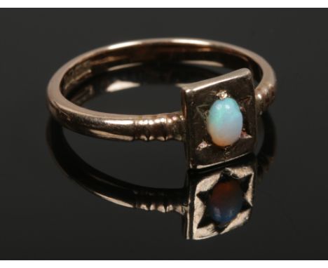 A 9ct gold gypsy set opal ring with stepped shoulders, size L. 