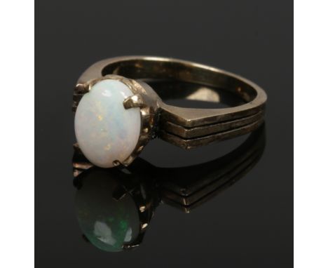 A 1970s yellow metal claw set opal ring, size J 1/2. 