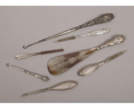 A collection of silver handled manicure tools, button hooks and a shoe horn. 