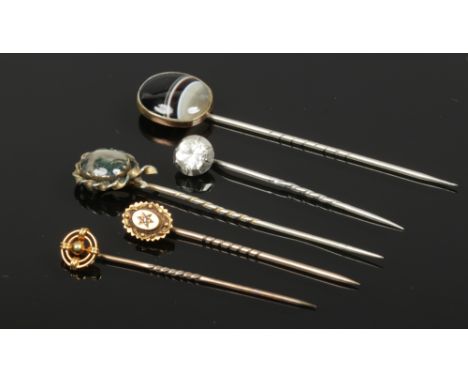 Two Victorian 15ct gold stick pins and three other antique examples including moss and banded agate. 