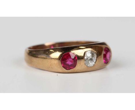 A gold, diamond and synthetic ruby ring, gypsy set with the cushion cut diamond between two cushion cut synthetic rubies, unm