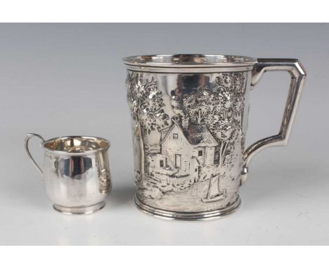 An American 'Pure Coin' silver tankard of tapering cylindrical form, chased in relief with a rural scene of houses and trees 