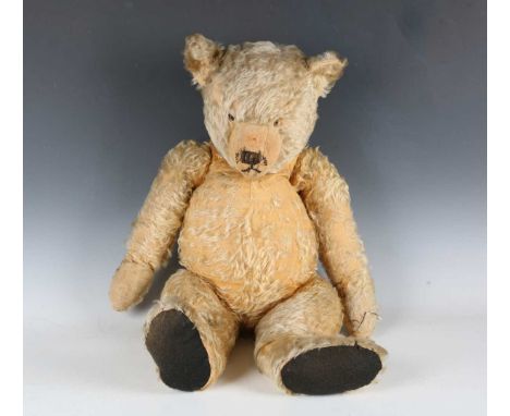 A mohair teddy bear with stitched snout and jointed body with fabric pads, height 68cm (bald patches, missing eyes and repair