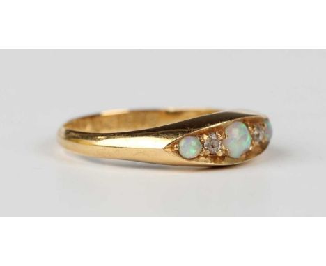 An Edwardian 18ct gold, opal and diamond ring, mounted with three circular opals alternating with two cushion cut diamonds in