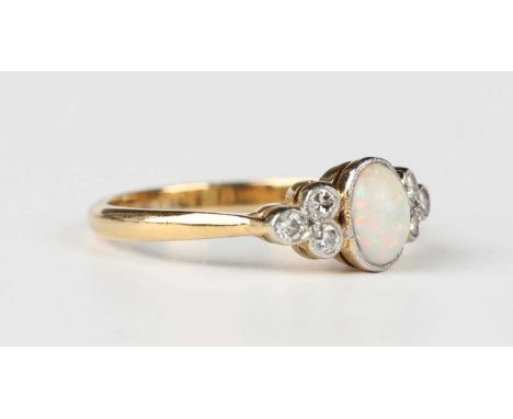 A gold, opal and diamond ring, collet set with the oval opal between circular cut diamond three stone sides, detailed ‘18ct’,