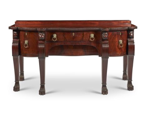 A GEORGE IV CARVED MAHOGANY SIDEBOARDCIRCA 1825Of breakfront serpentine outline, the shaped top with gadrooned edge, above an