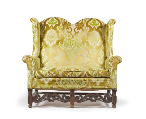 A WALNUT AND UPHOLSTERED WINGBACK SOFA IN WILLIAM & MARY STYLELATE 19TH CENTURY AND LATER UPHOLSTEREDThe double-arched back w