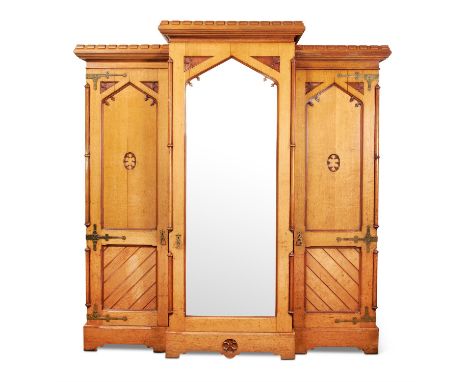 A VICTORIAN GOTHIC REVIVAL TRIPLE WARDROBEMANNER OF CHARLES EASTLAKE, CIRCA 1870The central arcaded mirror panel door enclosi
