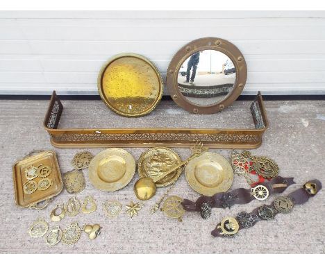 Mixed brassware including horse brasses, fire fender and similar and a circular wall mirror. [2]