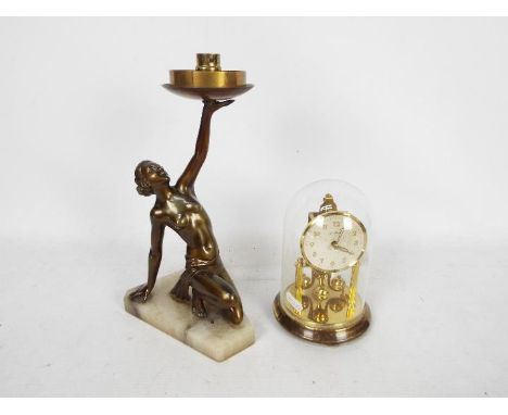 A brass torsion mantel clock by Bentima, with glass dome, approximately 17 cm (h) and a figural table lamp base. [2]