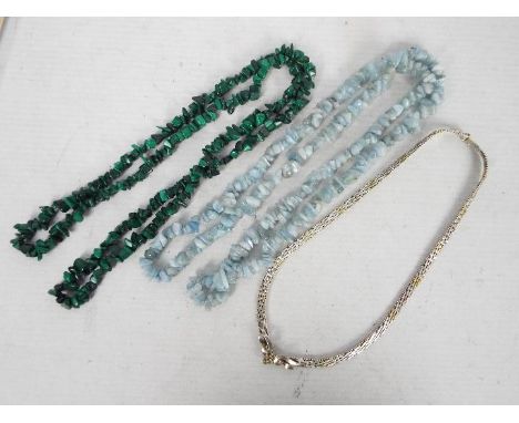 A malachite chip necklace, approximately 84 cm (l), a similar necklace with light blue stones and a white metal necklace stam