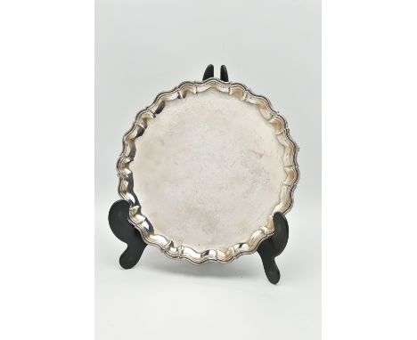 AN EDWARDIAN SILVER SALVER, polished round wavy form, raised on three scroll feet, hallmarked 'James Dixon &amp; Sons Ltd' Sh