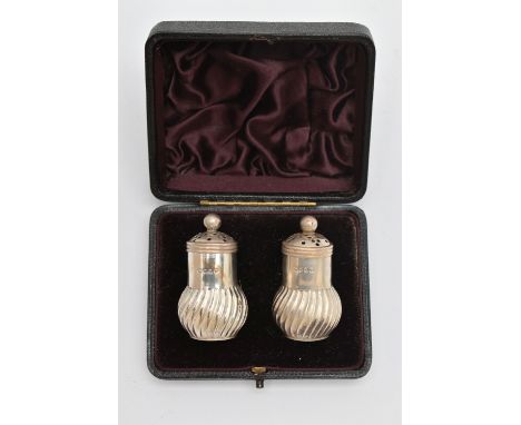 A CASED PAIR OF LATE VICTORIAN SILVER PEPPERETTES, baluster swirl form, pierced covers with ball finials, rubbed makers mark,