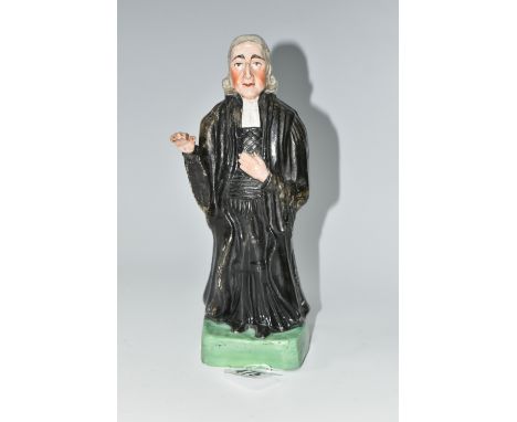 AN EARLY 19TH CENTURY STAFFORDSHIRE PEARLWARE FIGURE OF REV. JOHN WESLEY STANDING WITH ONE ARM RAISED, wearing black clerical