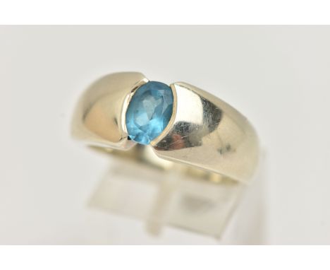 A 9CT GOLD TOPAZ RING, oval cut blue topaz half bezel set, set in a wide tapered white gold band, approximate width 9.5mm, ha