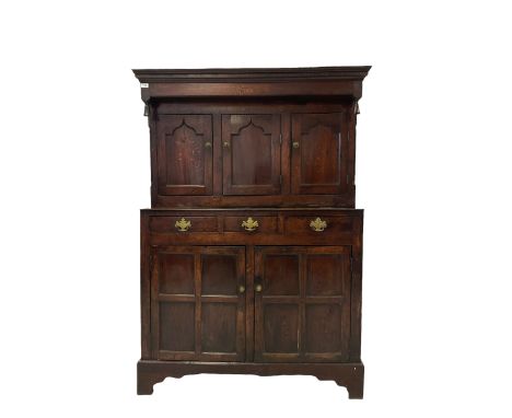 Georgian and later oak court cupboard, the projecting frieze over three panelled cupboards, three drawers and two cupboards, 