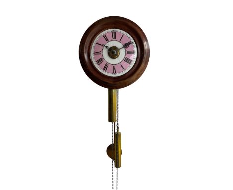 A late 19th century German “postman's” alarm clock with a 11” wooden bezel and 7” dial with contrasting pink chapter ring and