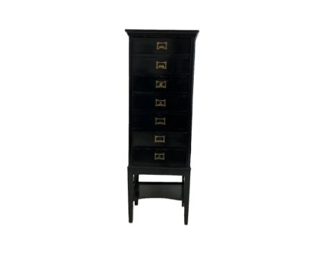 Ebonised sheet music cabinet, the projecting top over seven fall front drawers with Wellington style lock and one under-tier 