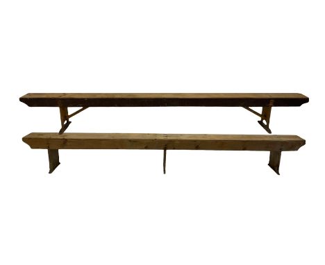 Two pine benches, raised on panel supports 
