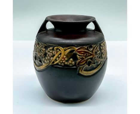 A small double-handled round vase in a brown semi-matte finished and adorned in an Art Nouveau style grape pattern. R stamped